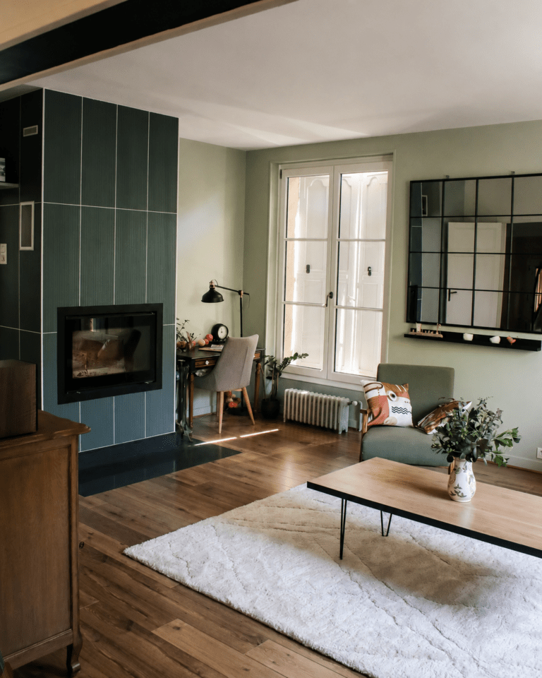 Rénovation salon maison ancienne à Blois avec fauteuil vert, miroir noir et table basse en bois